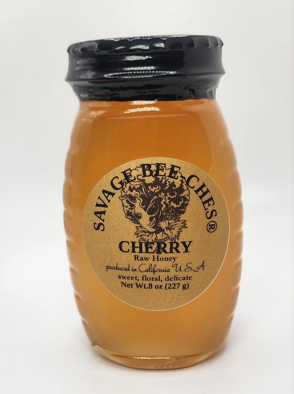 Close-up of the California Cherry Raw Honey label and golden honey