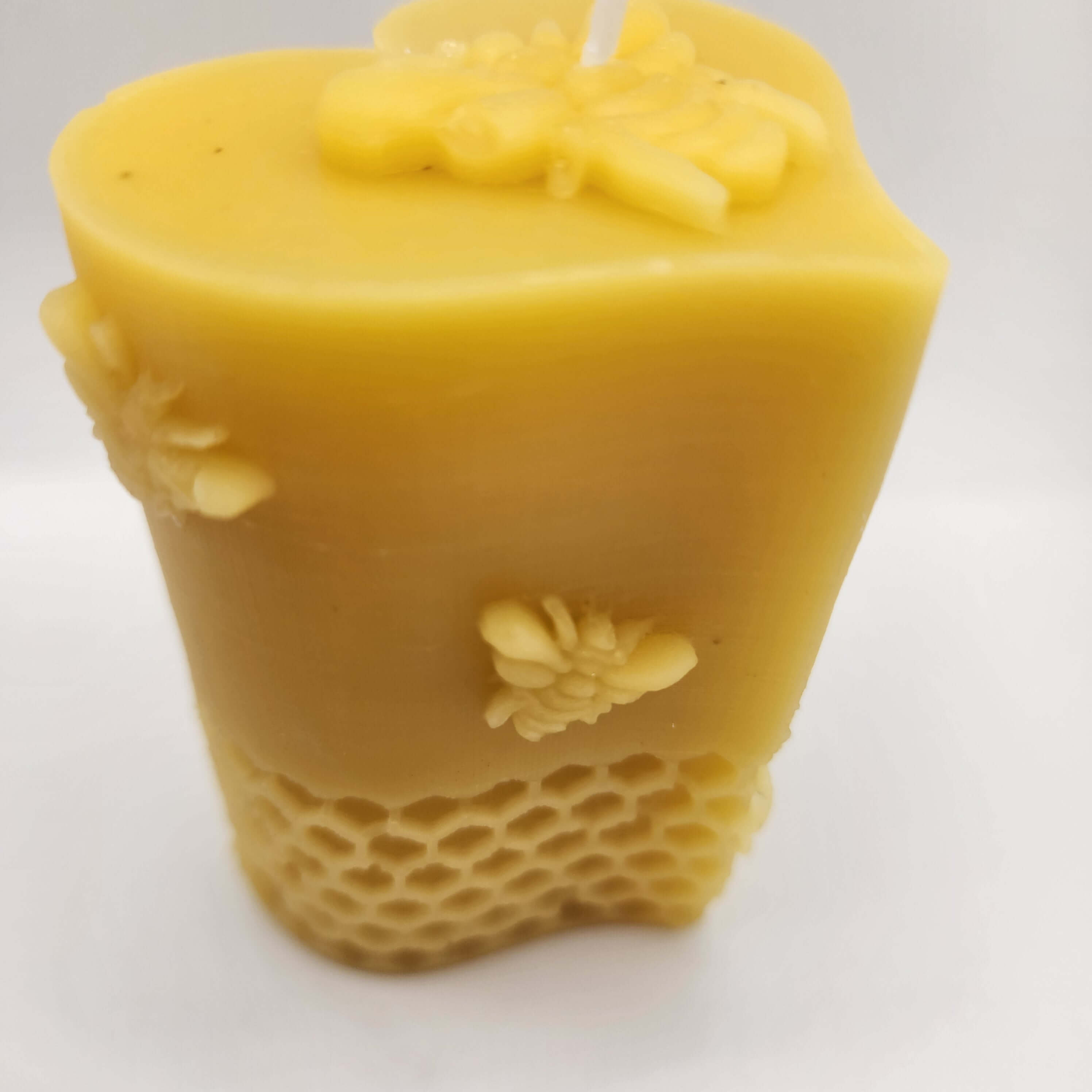 Handcrafted heart-and-bees beeswax candle with a warm natural finish
